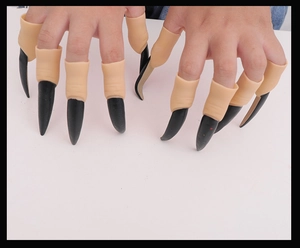 Close-up of long black Halloween costume claws worn on fingers for party decoration