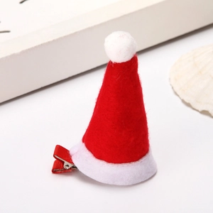 Detailed view of a red felt mini Santa hat hair clip with white pompom and alligator clip