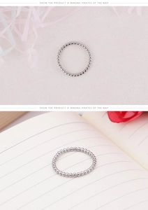 Détail de la bague perlée en acier argenté avec ruban élégant et mise en scène lifestyle