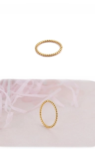 Detailed view of a gold beaded stackable ring with polished stainless steel finish
