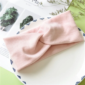 Detail of pink knitted headband with twist knot on a decorative ceramic plate