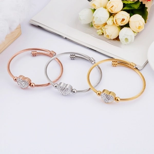 Three twisted wire heart bracelets in rose gold, silver, and gold with crystal accents
