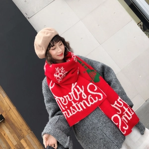 Detail of red Christmas scarf featuring white snowflakes and Merry Christmas knit pattern