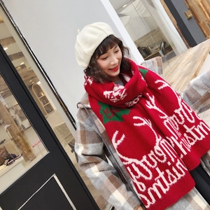 Detail of red knit Christmas scarf with white reindeer and Merry Christmas text