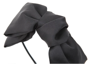 Detail of elegant black double-layered satin bow headband with smooth fabric texture