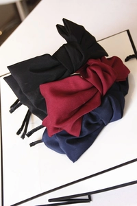 Detail of oversized double-layered satin bow headbands in black, burgundy and navy colors