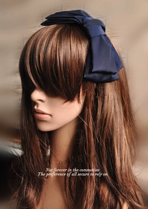 Detailed view of deep blue double-layered satin bow headband on a brown hair model
