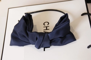 Detailed view of a navy blue oversized satin bow headband with a twisted knot design