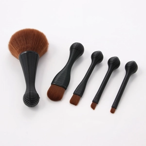 Detail of 5-piece makeup brush set featuring black spiral handles and dense red bristles