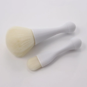 Detailed macro view of two portable makeup brushes with white spiral handles and soft bristles