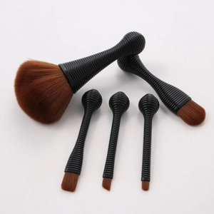 Set of five portable makeup brushes with brown synthetic bristles and black textured handles