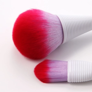 Macro detail of red-purple gradient bristles and white threaded makeup brush handles