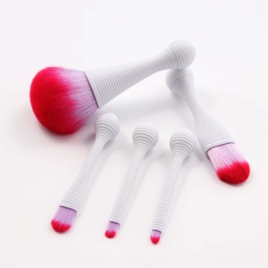Detail of 5-piece makeup brush set with white spiral handles and pink gradient bristles