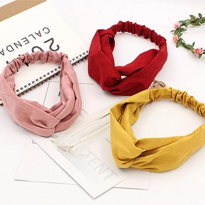 Three-piece set of knitted twisted cross headbands in pink, red, and yellow colors