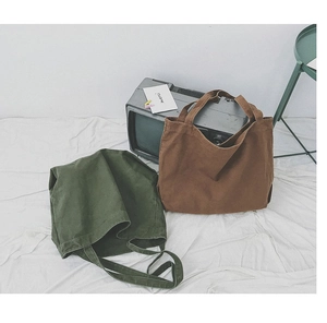 Close-up of military green and brown canvas tote bags on a vintage white background