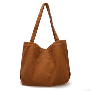 Minimalist brown canvas tote bag with large capacity in a sleek shoulder strap design