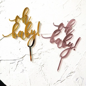 Detail of gold and rose gold acrylic oh baby cake toppers with mirror finish texture