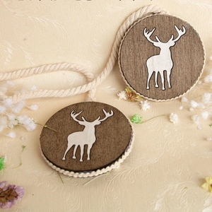 Detail of wooden magnetic curtain tieback with reindeer silhouette and woven rope edge