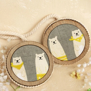 Detail of wooden magnetic curtain tiebacks featuring polar bear fabric patterns on warm texture