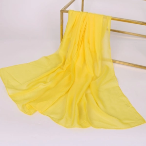 Elegante sciarpa lunga in chiffon giallo appesa a un supporto in metallo con drappeggio