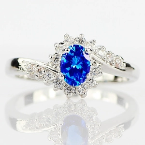 Elegante anello d'argento a spirale con zircone blu ovale e piccoli cristalli decorativi
