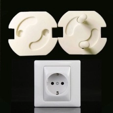 Close-up of white safety socket covers for toddlers on a European power outlet
