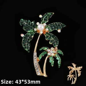 Detail of tropical gold palm tree brooch with green crystals, pearl and pin backing
