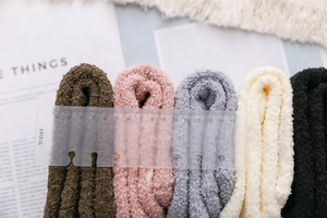 Close-up of thick coral fleece socks in five colors showing soft plush texture and size