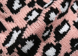 Close-up of thick knit leopard print fabric in pink, black, and white textures