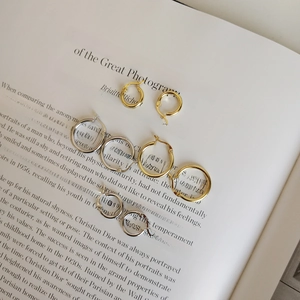 Minimalist 925 sterling silver hoop earrings in gold and silver finish on book