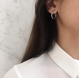 Sleek 925 sterling silver hoop earrings for women shown worn on ear with white shirt
