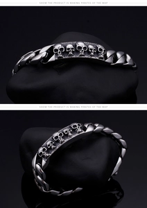 Macro detail of retro silver skull engraved plate on heavy Cuban link chain bracelet