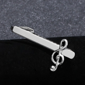 Silver musical G-clef note tie clip with polished finish on black velvet background