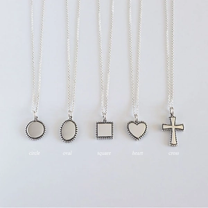 Detail of five S925 silver necklaces with circle, oval, square, heart and cross pendants