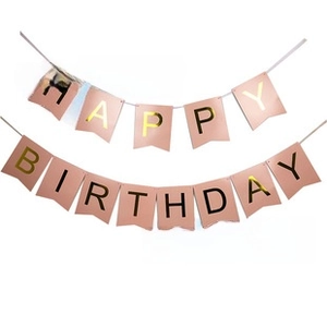 Close-up of pink Happy Birthday cardstock banner with gold foil lettering for parties