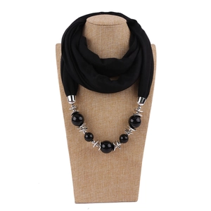 Detail of black fabric scarf necklace with oversized beads and silver metal rings