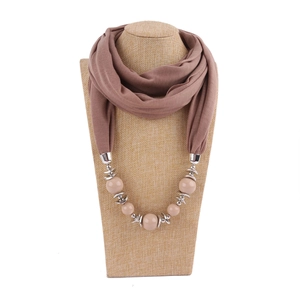 Close-up of brown scarf necklace with large beige beads and silver metal ring details