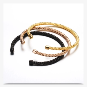 Detailed macro shot of twisted cable cuff bracelets in gold, rose gold and black finish
