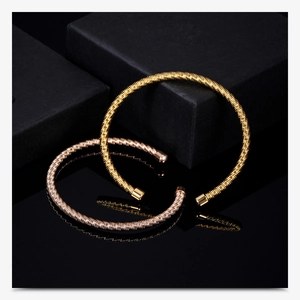 Detail view of twisted cable stainless steel bangles in gold and rose gold finish