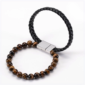 Detail of tiger eye stone beads and black braided leather bracelet with magnetic clasp