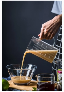 Detailed view of 500ml heat-resistant glass measuring cup pouring liquid in a kitchen setting