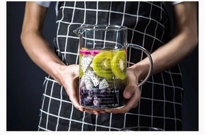 Close-up of 1000ml heat-resistant glass measuring cup with handle and fruit inside