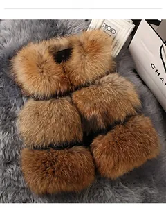 Detail of premium brown raccoon fur collar and matching cuffs on a soft plush background