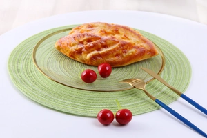 Detailed top view of a green woven round placemat with textured spiral ramie fibers