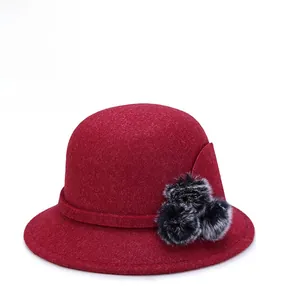 Elegant red wool cloche bucket hat with fur pom-poms for winter and autumn styles.