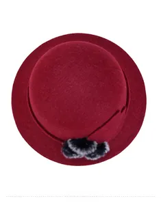 Vista dall'alto di un cappello di lana bordeaux da donna con pon pon bicolore decorativo