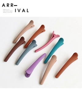 Macro shot of assorted matte finish duckbill hair clips in various Morandi colors