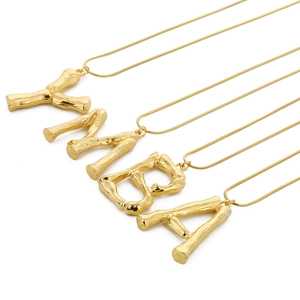 Bamboo style gold letter pendants Y, M, V, B, A on fine chains over white background