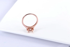 Close-up of rose gold halo engagement ring with pavé diamonds and four-prong setting