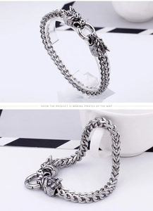 Macro shot of silver dragon heads and woven chain bracelet in punk viking style